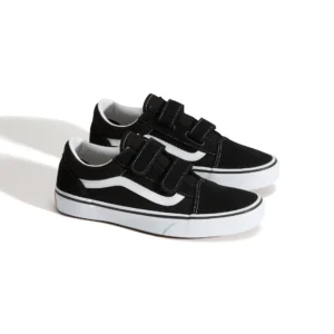 Zwarte sneakers met witte strepen en klittenband sluitingen op witte achtergrond