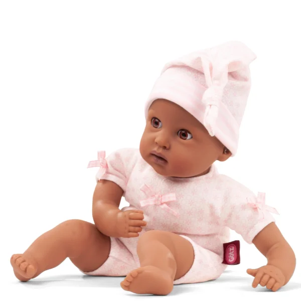 Babypop met donkere huidskleur in roze rompertje en bijpassend mutsje met strik