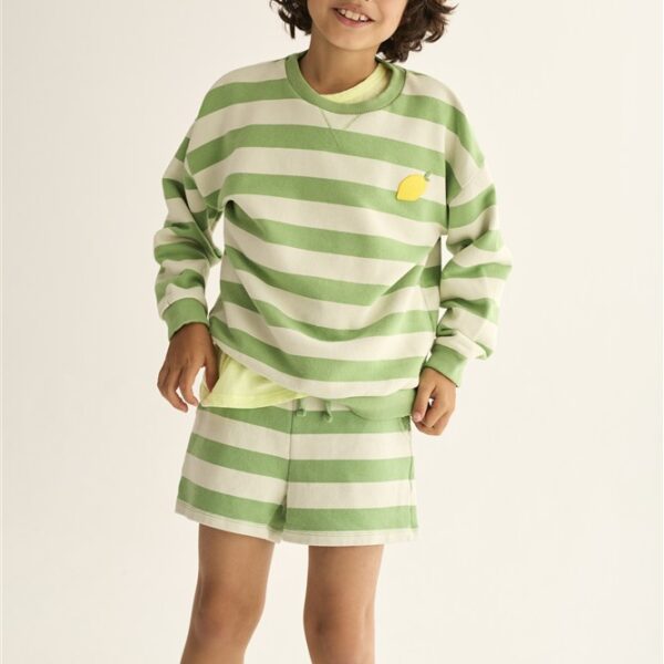 Jongen met krullend haar in groen-wit gestreepte sweater en korte broek met geel detail