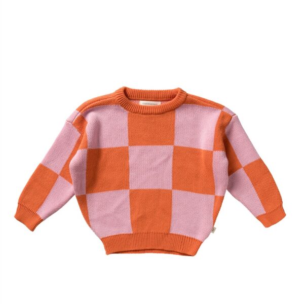 Gebreide kindertrui met oranje en roze geblokt ruitpatroon op witte achtergrond