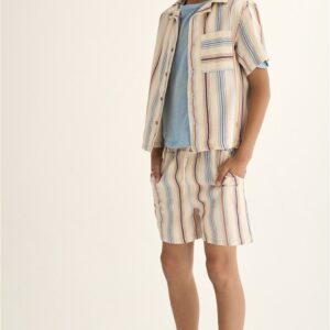Jongen in gestreepte zomeroutfit met beige overhemd en shorts op witte achtergrond