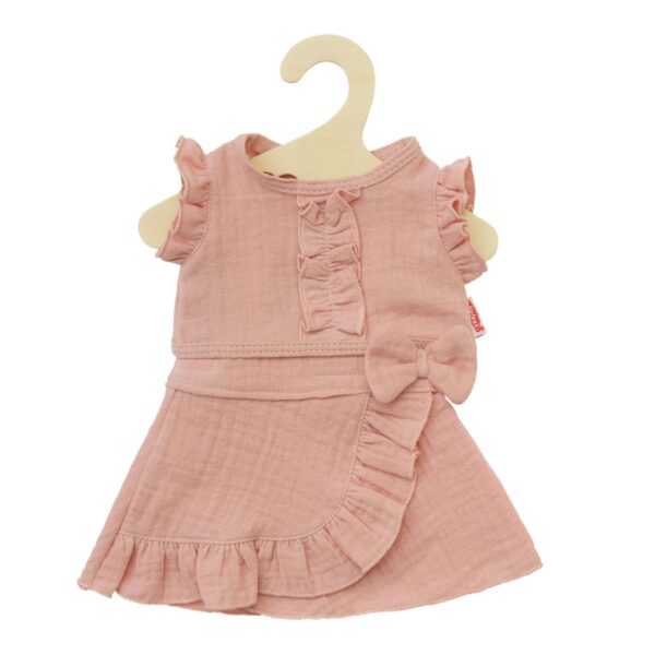 Roze poppenjurk met ruchesrand en strikdetail op houten kledinghaak voor poppen